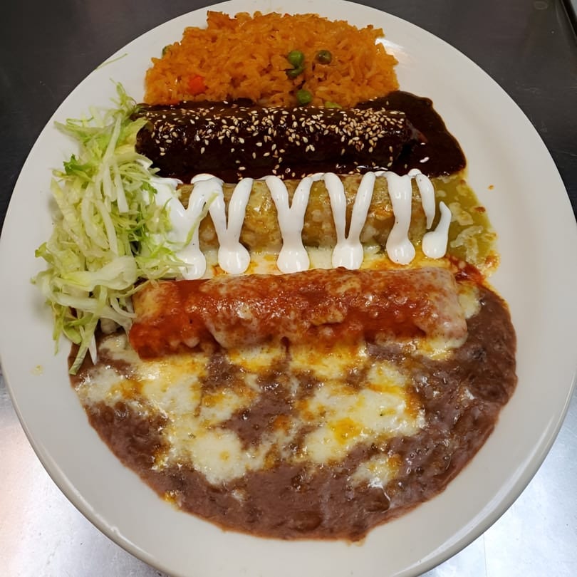A Cinco de Mayo 2 Mexican combination plate with enchiladas, rice, beans, and shredded lettuce.
